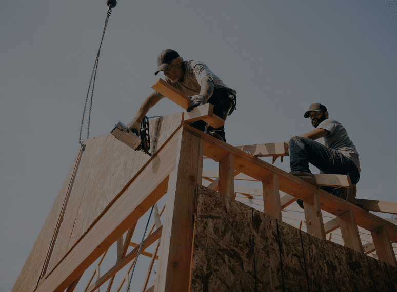 Construction workers assembling wooden roof structure.