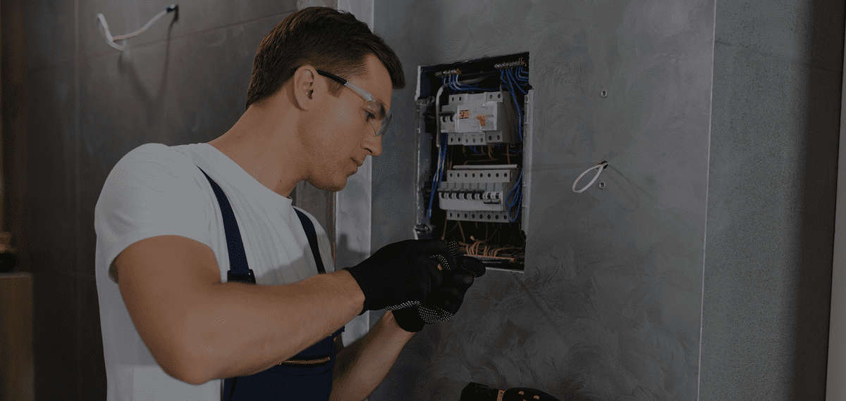 Electrician working on a circuit breaker panel.