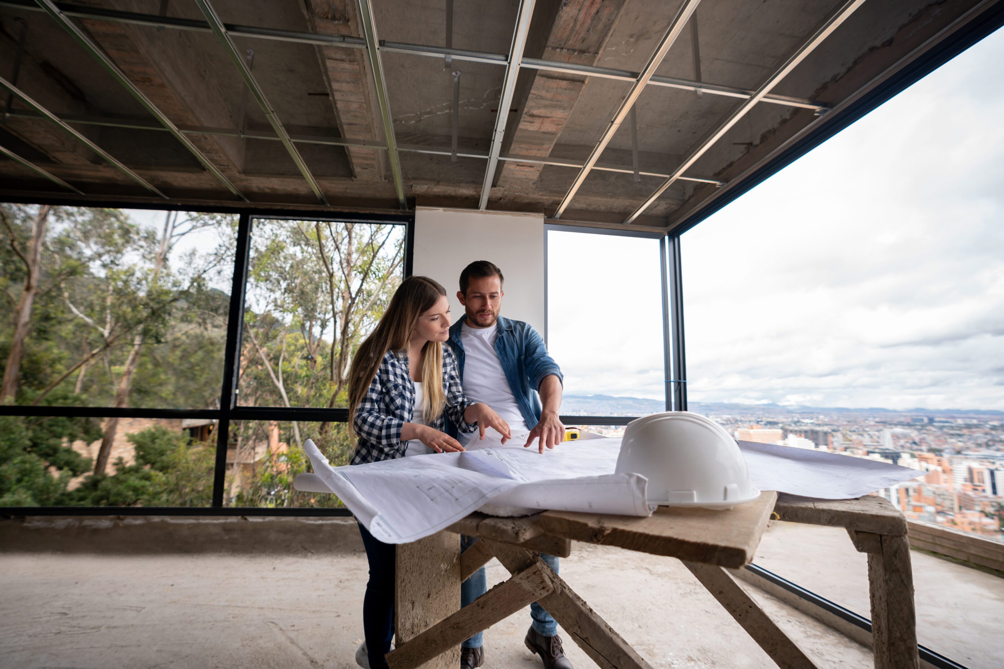 Architects reviewing blueprints in unfinished building.