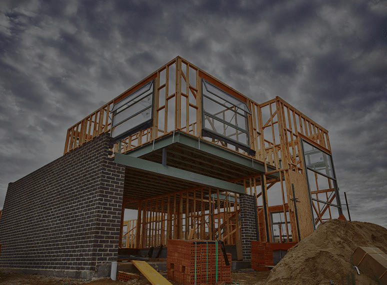 House under construction with cloudy sky.